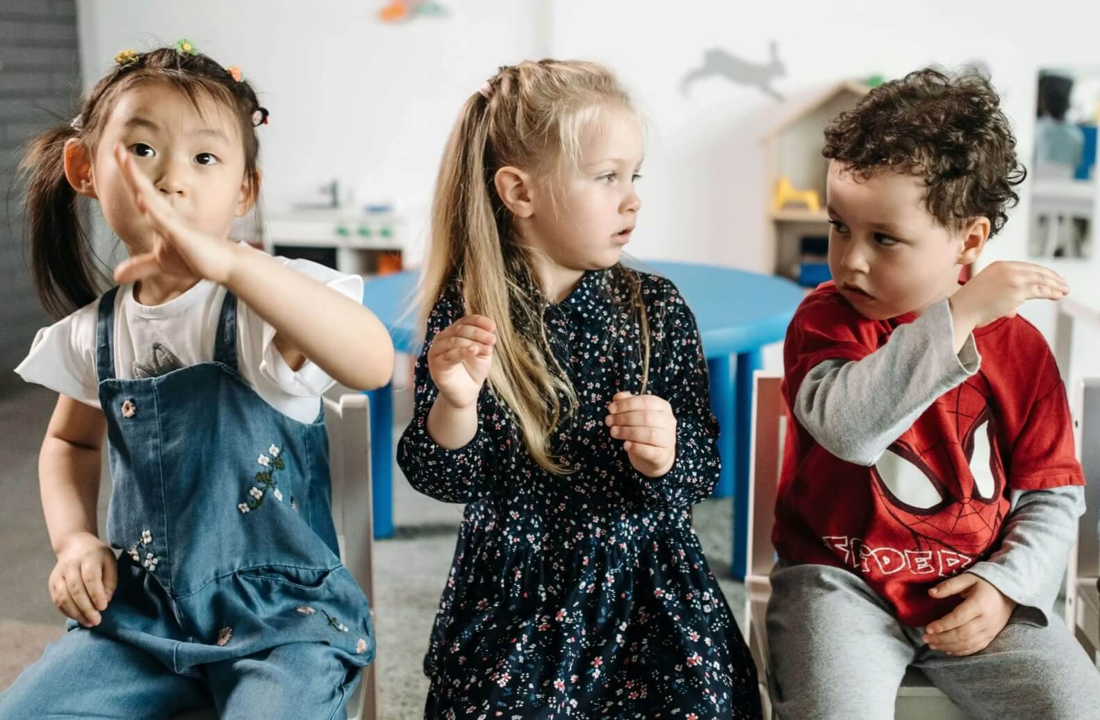 Three children playing a mime game